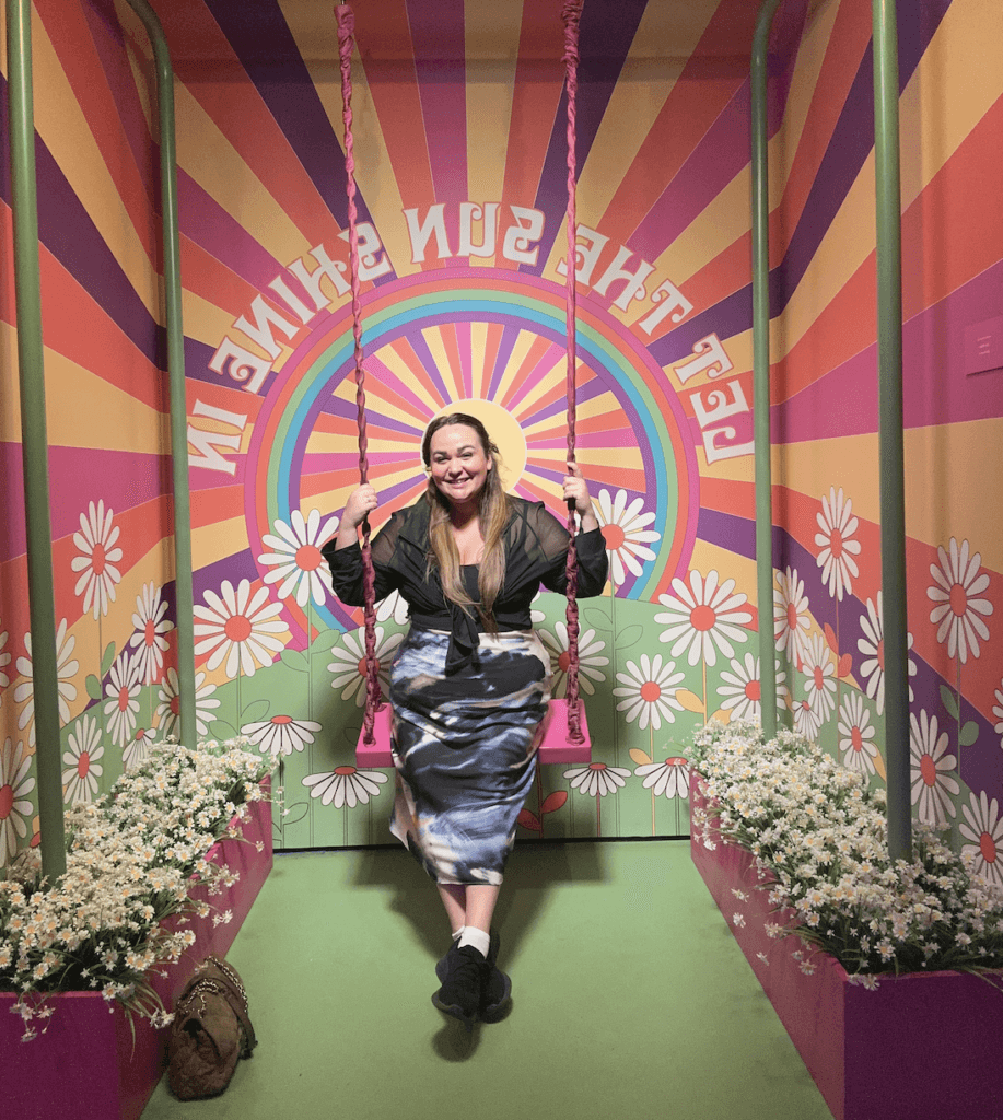 Ellie sat on a multicolored swing in the museum of broadway