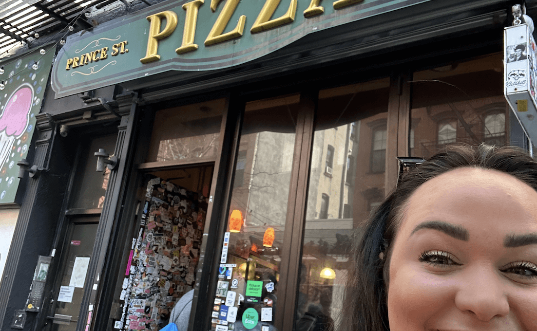 Ellie eating at Prince Street Pizza