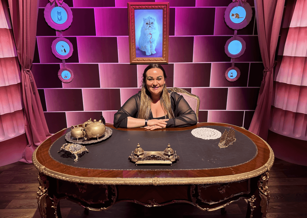 Ellie sitting at Umbridge's desk at harry potter exhibition