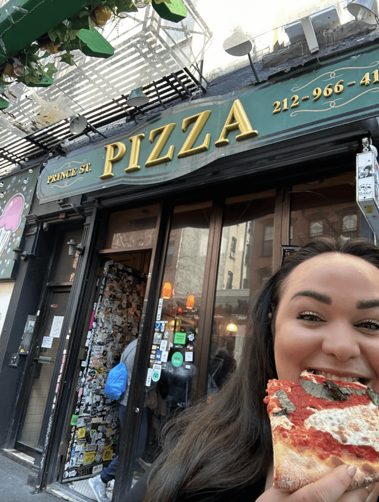 Ellie eating Prince Street Pizza in NYC