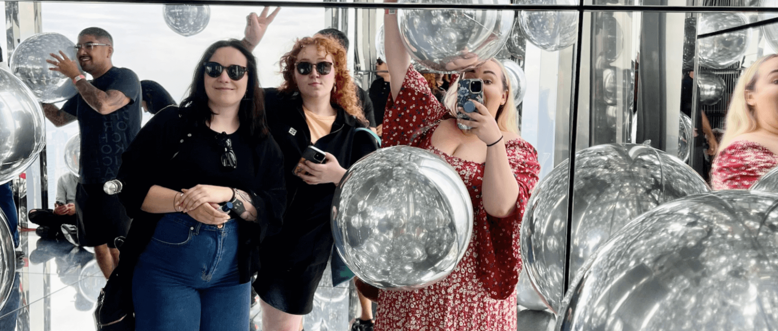 Group of women enjoying the mirrored-balloons in Summit One Vanderbilt, NYC.