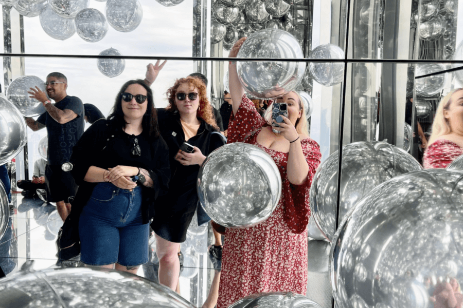 Group of women enjoying the mirrored-balloons in Summit One Vanderbilt, NYC.