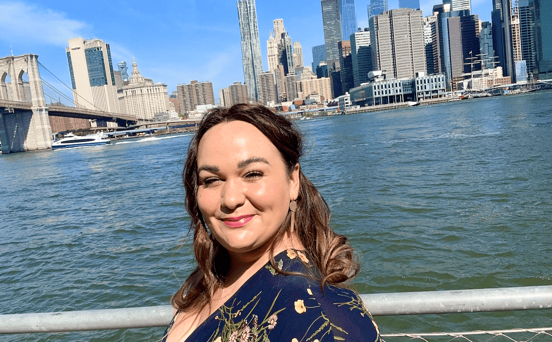 Woman standing in front of the Manhattan skyline in Brooklyn